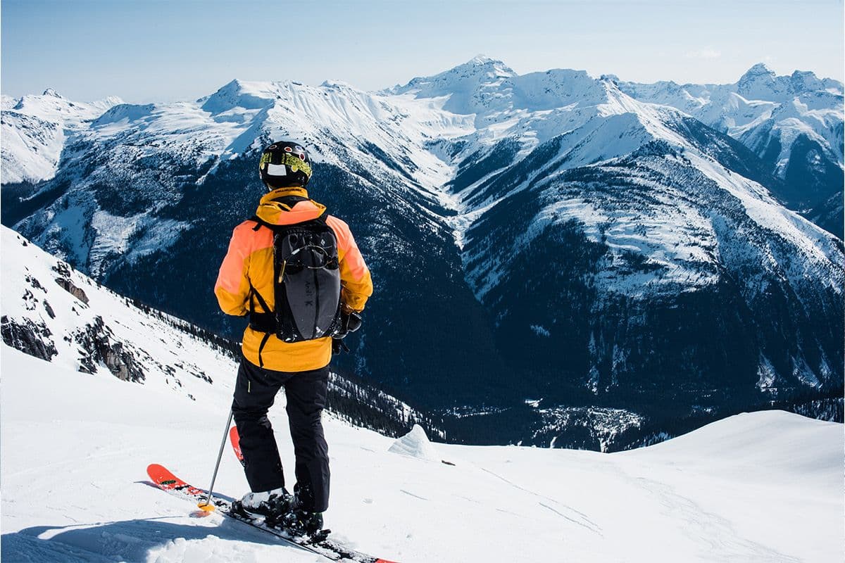 A first-time heli-skier smiling mid-run in fresh powder