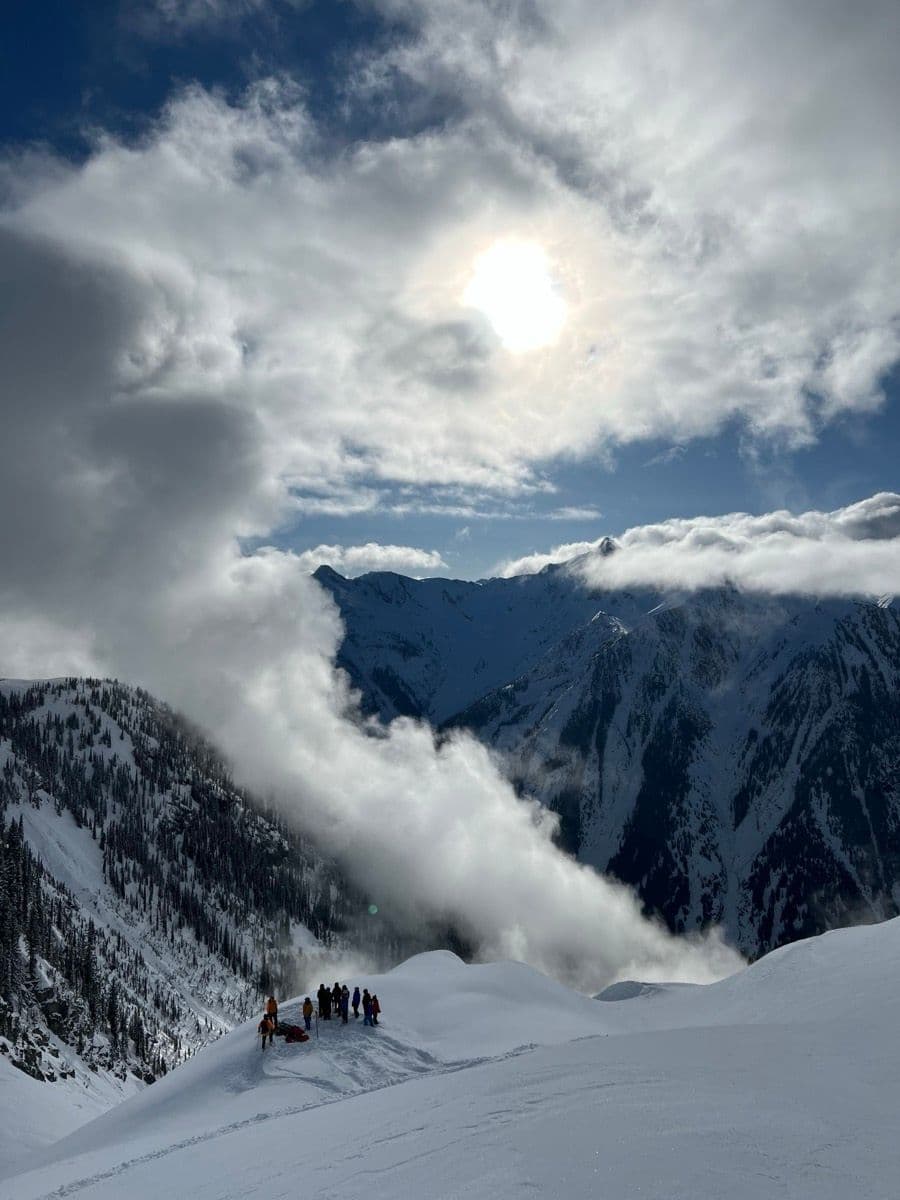 A CMH group gathered on a ridge above the clouds