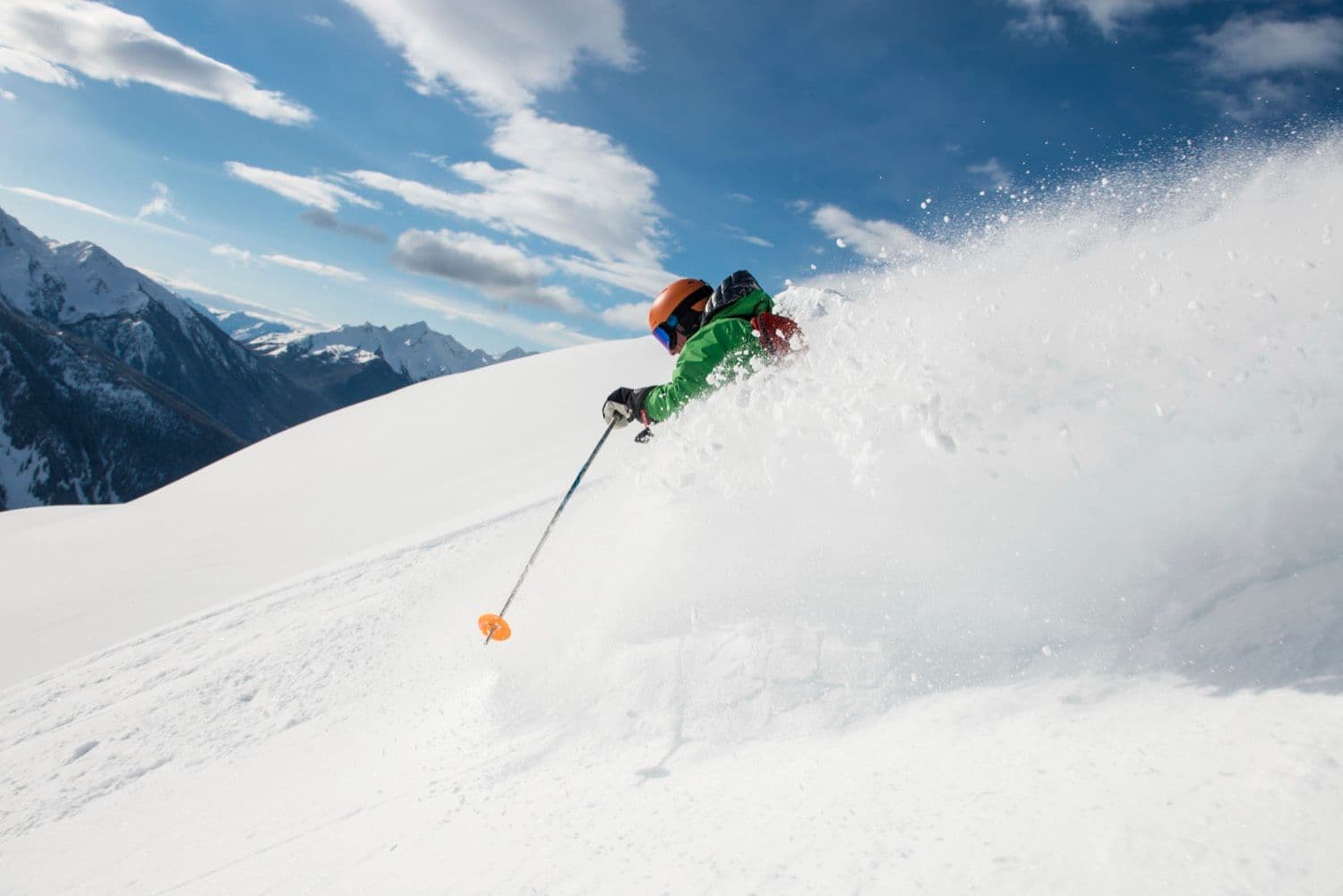 A skier carving a deep powder turn on a CMH heli-ski trip